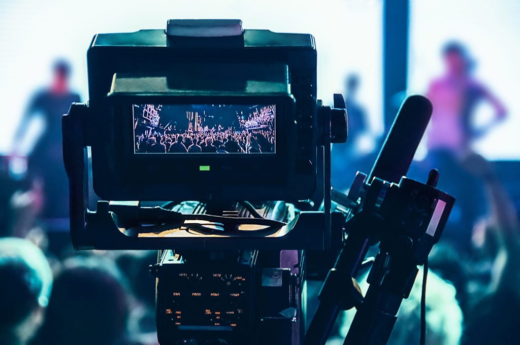 A professional video camera filming a concert