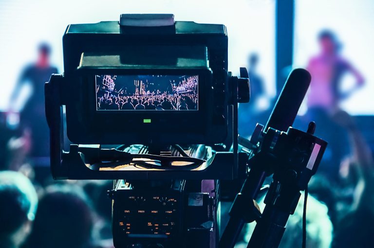 A professional video camera filming a concert