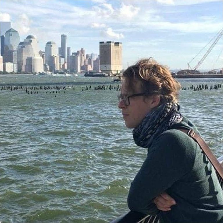 Joe on the Hudson River waterfront with the Lower Manhattan skyline behind him
